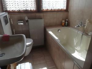 Un baño con bañera, inodoro y lavabo. en Ferienhaus Hebborn, en Bergisch Gladbach 32 fotos más