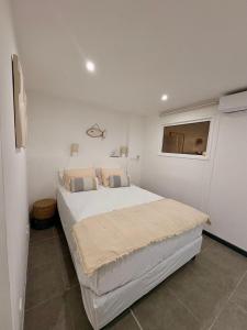Un dormitorio con una cama grande en una habitación blanca. en Always Sun ,1 bdr up to 4 guests, en Baie Nettle