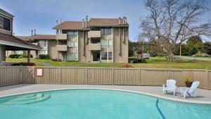 a swimming pool with two chairs and a fence at Mutiny Bay Condo by AvantStay Walk to the Beach in Freeland