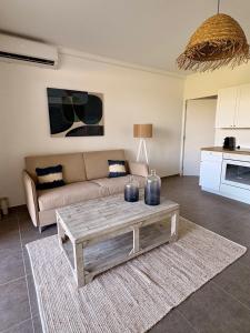 Una sala de estar con un sofá y una mesa de café. en Always Sun ,1 bdr up to 4 guests, en Baie Nettle