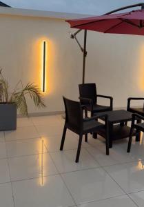 dos sillas y una mesa con sombrilla en Goldenstay apartment, en Mama 5 fotos más