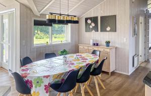a dining room with a table and chairs at Cozy Home In Rudkøbing With Sauna in Spodsbjerg