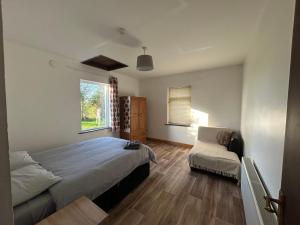 a bedroom with a bed and a chair and a window at Ciaran's cottage in Donore