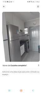 Una imagen de una cocina con un refrigerador de acero inoxidable. en Vista Deslumbrante, en Mongaguá