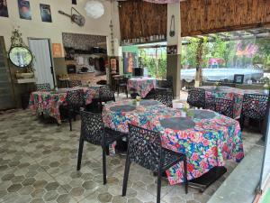un restaurante con mesas y sillas con un colorido mantel en Hotel Pousada Casa Verde, en Cordisburgo