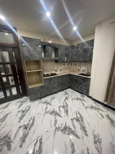 a kitchen with a marble floor in a room at Royal Apartments-One Bed Apartments in Islamabad