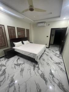a bedroom with a bed and a marble floor at Royal Apartments-One Bed Apartments in Islamabad
