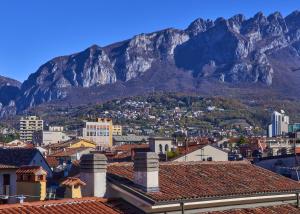 a view of a city with a mountain in the background at Verde Acqua two Apartments in Lecco
