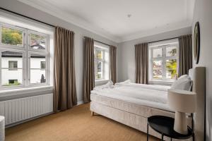 Un dormitorio con una cama grande y dos ventanas. en Elegant Historic Villa - Stunning Views, en Bergen