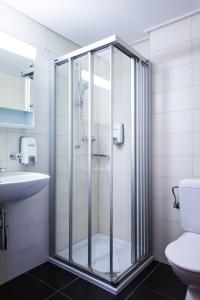 y baño con ducha de cristal y lavabo. en Hotel Castel en Sion
