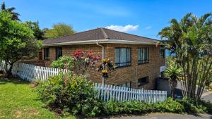 a brick house with a white picket fence at Guernsey Flat in Port Shepstone