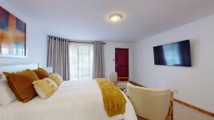 a bedroom with a white bed and a window at Guernsey Flat in Port Shepstone