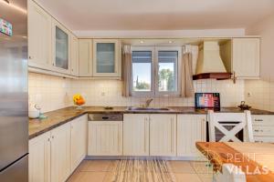 a kitchen with white cabinets and a sink at Villa Mare Magna in Plépi
