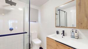 a bathroom with a toilet and a sink and a mirror at Guernsey Flat in Port Shepstone