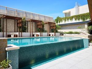 ein Schwimmbad vor einem Gebäude in der Unterkunft Novotel Sydney Cabramatta in Cabramatta