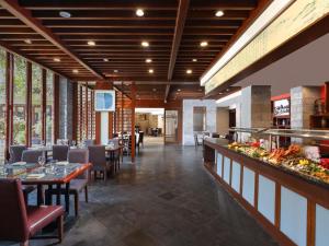 a restaurant with tables and chairs and a buffet at Grand Mercure Sanya Yalong Bay in Sanya