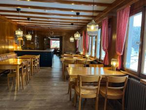 a restaurant with wooden tables and chairs and windows at Berggasthaus Auerhahn - Ski In- Ski Out- in Feldberg