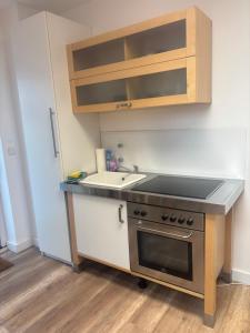 una cocina con fregadero y estufa en Apartment nah Flughafen, Messe, Arena, Dome, en Düsseldorf