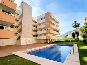 een appartementencomplex met een zwembad ervoor bij Centrally Located Penthouse A103 in Las Lagunas Mijas