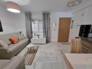 een woonkamer met een bank en een televisie bij Centrally Located Penthouse A103 in Las Lagunas Mijas
