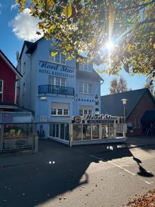 ein großes weißes Gebäude mit einem Schild darauf in der Unterkunft Hotel-Restaurant Nord Stuv in Cuxhaven