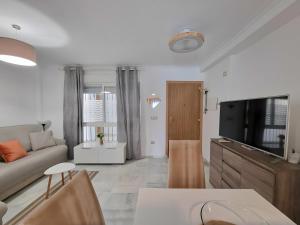 een woonkamer met een bank en een tv bij Centrally Located Penthouse A103 in Las Lagunas Mijas