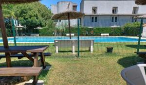 a pool with a picnic table and an umbrella at casa andaluza 109 in Novo Sancti Petri