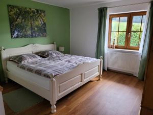 una camera con un letto bianco su una parete verde di Ferienwohnung Sommerseite a Seebach