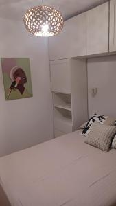a white bedroom with a bed and a chandelier at casa andaluza 109 in Novo Sancti Petri +32 photos
