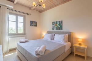 a bedroom with a bed with towels on it at Elia Villas in Riglia +42 photos