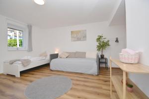 Sala de estar blanca con cama y sofá en CO10 - Ferienwohnung in Coburg, en Coburg