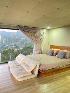 een slaapkamer met een groot bed met een groot raam bij แล้วแต่เพื่อนวิลล่า in Ban Huai Khai