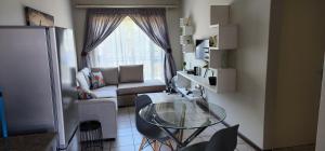 a living room with a glass table and a couch at Peaceful Casa in Kempton Park +2 photos