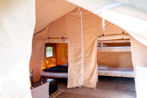 een tent met daarin meerdere stapelbedden bij Camping De Thoissey *** in Thoissey