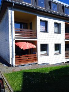 a house with a red umbrella sitting on a bench at Ferienwohnung Jesper in Braunlage