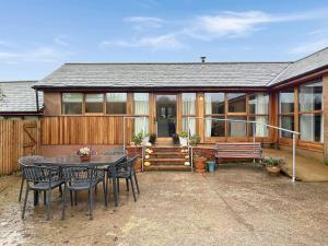 a house with a patio with a table and chairs at Westlands Brendon Hill in Treborough
