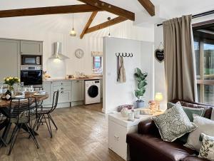 a living room and kitchen with a couch and a table at Westlands Brendon Hill in Treborough