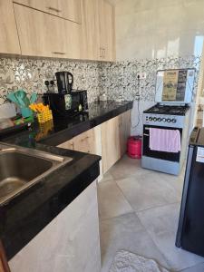 a kitchen with a sink and a stove at Zuri Homes 6 B in Mombasa