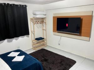 a room with a bed and a flat screen tv at Panama 90 - Studio - Região Central in Poços de Caldas