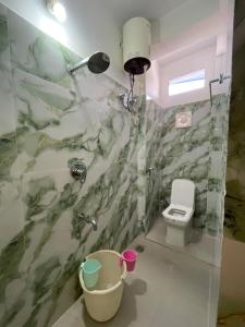 a bathroom with a shower and a toilet at Karma Stay 2BHK apartments in Jaigaon +16 photos