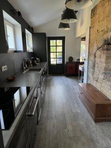 a kitchen with a stone fireplace and a sink at Rest & Relax Doubice in Doubice