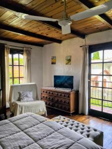 a bedroom with a bed and a chair and windows at Chalet Caserón de Tejas, Amplia y confortable casa para hasta 11 huéspedes in Mar del Plata +73 photos