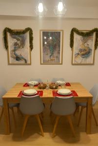 a wooden dining room table with two chairs and two paintings at VuT El Refugio de Santiago in Ávila +9 photos