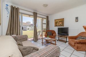 a living room with a couch and a tv at Hermanus Beach Club in Hermanus