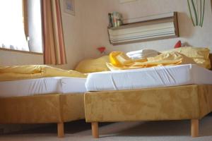 two beds sitting in a room with yellow sheets at Chalet Auhof in Flachau
