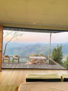 een kamer met een tafel en uitzicht op de bergen bij แล้วแต่เพื่อนวิลล่า in Ban Huai Khai +15 foto's