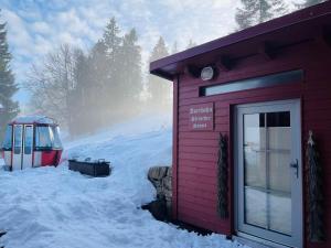 a small red building with snow around it at Berggasthaus Auerhahn - Ski In- Ski Out- in Feldberg +19 photos