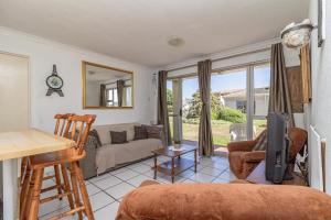 a living room with a couch and a tv at Hermanus Beach Club in Hermanus