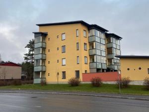 a yellow apartment building on the side of a street at Mimosa in Tampere