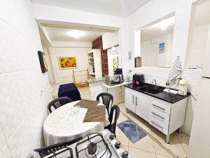 a kitchen and dining room with a table and a sink at CASA COMPLETA 5min DA PRAIA JUQUEHY in São Sebastião +11 photos